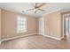 Bright bedroom features a ceiling fan, wood-look floors, a window, and a white door at 708 Alexis Dr., Longs, SC 29568