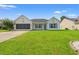 Charming single-story home with a lush green lawn and beautiful blue shutters against a clear blue sky at 708 Alexis Dr., Longs, SC 29568