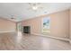 Large living room with wood-look floors, a cozy fireplace, and a window showcasing a green view at 708 Alexis Dr., Longs, SC 29568