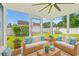 Bright sunroom with wicker furnishings, a ceiling fan, and large windows showcasing a lovely backyard at 708 Alexis Dr., Longs, SC 29568