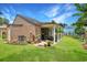Exterior view of the backyard featuring a covered patio, manicured lawn, and landscaping at 709 Jerdon Circle, North Myrtle Beach, SC 29582