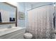 Light filled bathroom with a sink, white cabinet, and a shower with a stylish leaf-patterned curtain at 754 Salerno Circle # F, Myrtle Beach, SC 29579