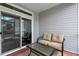 Cozy covered porch with a love seat, glass table, and a colorful rug with easy access to the outdoors at 754 Salerno Circle # F, Myrtle Beach, SC 29579