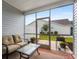 Relaxing screened porch with comfortable seating, plants, and a view of the outdoors and a white fence at 754 Salerno Circle # F, Myrtle Beach, SC 29579