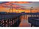 Sunset view of a long boardwalk along the water with lamp posts and buildings in the background at 7601 N Ocean Blvd. # 3-B, Myrtle Beach, SC 29572
