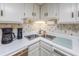 Functional kitchen featuring stainless steel sink, bright cabinetry, and standard appliances at 7601 N Ocean Blvd. # 3-B, Myrtle Beach, SC 29572