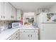 Bright kitchen features white cabinets, countertops, and appliances at 7601 N Ocean Blvd. # 3-B, Myrtle Beach, SC 29572