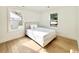 Sunlit bedroom with hardwood floors, two windows, and a comfortable bed with neutral bedding at 7610 Driftwood Dr., Myrtle Beach, SC 29572
