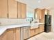 Bright kitchen featuring light wood cabinets, stainless steel appliances, and a farmhouse sink at 7610 Driftwood Dr., Myrtle Beach, SC 29572