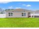 The back exterior features a grassy yard, gray siding, and windows at 821 Twickenham Loop, Longs, SC 29568