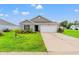 Charming single-story home with a well-manicured lawn, palm tree, and a two-car garage at 821 Twickenham Loop, Longs, SC 29568