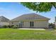 Home exterior featuring a backyard patio, manicured lawn, and neutral-colored siding at 8708 Coosaw Ct., Myrtle Beach, SC 29577