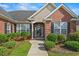 Close-up shot of the front brick exterior showcasing the inviting entrance and well-kept landscaping at 8708 Coosaw Ct., Myrtle Beach, SC 29577