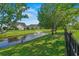 Community pond featuring a fountain, well-manicured lawn, and black metal fencing at 8708 Coosaw Ct., Myrtle Beach, SC 29577