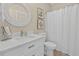 Bright bathroom featuring a round mirror, modern vanity, and a clean shower curtain at 901 W Port Dr. # 2114, North Myrtle Beach, SC 29582