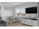 Bright dining area featuring a table, seating, and a television; 'Love you to the beach and back' sign at 920 N Waccamaw Dr. # 2310, Murrells Inlet, SC 29576
