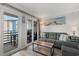 Inviting living room with balcony access, featuring a comfortable gray sofa and a coastal-themed wall art at 920 N Waccamaw Dr. # 2310, Murrells Inlet, SC 29576