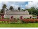 The Heather Glen community entrance is adorned with colorful flowerbeds and stone signage under a blue sky at 964 Irving Dr., Little River, SC 29566