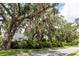 A glimpse of a home through mature trees, offering shade and curb appeal in a serene setting at 964 Irving Dr., Little River, SC 29566