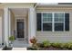 Charming covered entryway with decorative black door, black shutters, and complementary plants at 964 Irving Dr., Little River, SC 29566