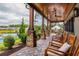 Covered patio with rocking chairs overlooking the pool and landscaped yard, creating a relaxing outdoor space at 964 Irving Dr., Little River, SC 29566