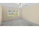 Bright bedroom featuring plush carpet, a ceiling fan, and a large window at 104 Ashton Circle, Myrtle Beach, SC 29588
