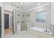 This bathroom features a glass enclosed shower, white soaking tub, and decorative chandelier at 1054 East Isle Of Palms Ave., Myrtle Beach, SC 29579