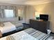 Nicely decorated bedroom features two beds, a dresser, a mirror and a TV at 1105 S Ocean Blvd. # 136, Myrtle Beach, SC 29577