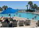 Lounge by the clear outdoor pool with palm trees, umbrellas, and many swimmers at 1105 S Ocean Blvd. # 136, Myrtle Beach, SC 29577