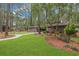 Well-maintained front yard with curved walkway and brick exterior, featuring mature trees and lush landscaping at 112 Birchwood Ln., Conway, SC 29526