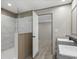 Modern bathroom with walk-in shower featuring marble-look tiling, white door, and view to the primary bedroom at 1126 Amanda Lane, Loris, SC 29569