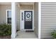 Close-up view of the front door, featuring a decorative wreath and a well-lit porch at 116 Kingsbury Loop # C, Conway, SC 29526