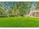 Expansive backyard with lush green lawn, mature trees, and a deck for outdoor enjoyment at 1176 Old Plantation Dr., Pawleys Island, SC 29585