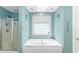 Soaking tub with a decorative window and shower in the background, offering a spa-like experience at 1176 Old Plantation Dr., Pawleys Island, SC 29585