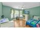 Brightly lit bedroom with hardwood floors, large windows, ceiling fan, and playful decor at 1176 Old Plantation Dr., Pawleys Island, SC 29585