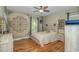 Relaxing bedroom with light walls, a light-colored bed, ceiling fan, hardwood floors, and a wall decoration at 1176 Old Plantation Dr., Pawleys Island, SC 29585