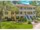 Charming two-story home with a double front porch, landscaped yard, and blue skies at 1176 Old Plantation Dr., Pawleys Island, SC 29585