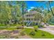 Beautiful two-story home featuring a double front porch, complemented by mature trees and landscaping at 1176 Old Plantation Dr., Pawleys Island, SC 29585