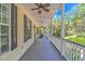 Relaxing covered porch with rocking chairs, ceiling fans, and a view of the lush outdoors at 1176 Old Plantation Dr., Pawleys Island, SC 29585