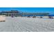 Beach scene showcasing lounge chairs with blue umbrellas and a pier on a sunny day at 1200 N Ocean Blvd. # 211, Myrtle Beach, SC 29577