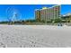 Sandy beach leading to a Ferris wheel and modern hotel complex under a clear sky at 1200 N Ocean Blvd. # 211, Myrtle Beach, SC 29577