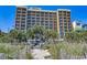 Multi-story condo building on a beach with palm trees and a sand dune at 1200 N Ocean Blvd. # 211, Myrtle Beach, SC 29577