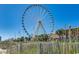 Ferris wheel on a bright day in front of a grassy dune and beach at 1200 N Ocean Blvd. # 211, Myrtle Beach, SC 29577