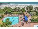 Stunning aerial view of pool area with ocean backdrop, palm trees, and lounge chairs, perfect for relaxation at 1200 N Ocean Blvd. # 211, Myrtle Beach, SC 29577