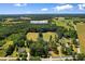 Wide aerial view shows a generous property and surrounding wooded areas and open fields at 1206 French Rd, Mullins, SC 29574