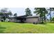 View of the rear of the property featuring brick siding and a large green lawn at 1206 French Rd, Mullins, SC 29574