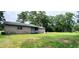 A rear view of the home, highlighting its brick exterior and expansive lawn at 1206 French Rd, Mullins, SC 29574