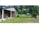 Covered porch with swing in view of a large grass backyard and a peek at fields at 1206 French Rd, Mullins, SC 29574