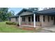 Charming brick home featuring a cozy front porch and well-maintained landscaping at 1206 French Rd, Mullins, SC 29574