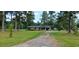 Quaint single-story brick home with a charming front porch surrounded by mature trees at 1206 French Rd, Mullins, SC 29574